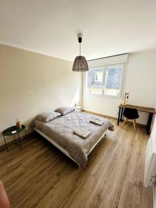 a bedroom with a bed and a desk in it at Convivial appartement de charme avec balcon , 95 m2 en hyper-centre de Saint-Brieuc. Tout confort, grand salon avec vidéoprojecteur - 3 chambres - Parking in Saint-Brieuc