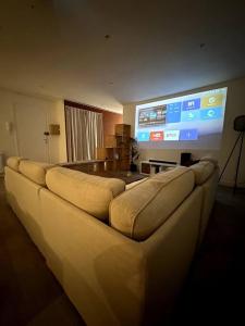 a living room with a couch and a large screen at Convivial appartement de charme avec balcon , 95 m2 en hyper-centre de Saint-Brieuc. Tout confort, grand salon avec vidéoprojecteur - 3 chambres - Parking in Saint-Brieuc