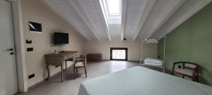 1 dormitorio con 1 cama, mesa y sillas en La Sarmassa, en Vernasca