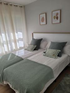 Un dormitorio con una cama con una manta verde. en Apartamento Azabache en Zaragoza