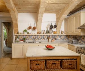 a kitchen with a counter with a bowl of fruit on it at CASA SAN ROCCO - Luxurious Grand 18th C. Palace with Gardens & Pool in Hal Ghaxiak