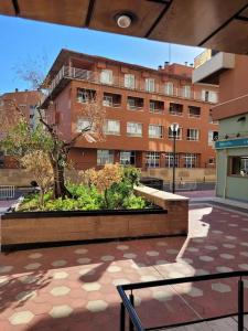 un banco en un patio frente a un edificio en Apartamento Azabache en Zaragoza