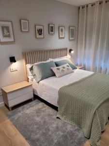 1 dormitorio con 1 cama grande y mesita de noche en Apartamento Azabache, en Zaragoza