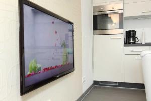 a flat screen tv hanging on a wall in a kitchen at Bungalow Mariannenweg 4 in Tarnewitz