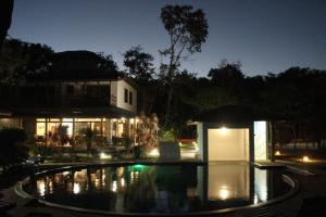 uma piscina em frente a uma casa à noite em Pousada Maré em Cumuruxatiba