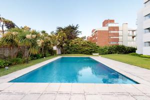 een zwembad in het midden van een tuin bij Oceana Suites en Esturion, frente a playa Brava in Punta del Este