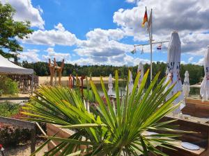 シュットルフにあるFerienwohnung Ferienpark Quendorferseeの白い傘と植物のあるパティオ