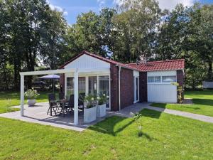 シュットルフにあるFerienwohnung Ferienpark Quendorferseeのパティオとガレージ付きの家