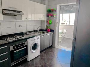 a kitchen with a washing machine and a sink at Appartement vue sur mer avec piscines in Mohammedia