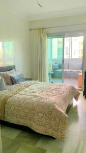 a bedroom with a large bed and a living room at Appartement vue sur mer avec piscines in Mohammedia