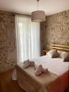 a bedroom with a large bed with two pillows on it at Casa Rochiña in Pobra do Caramiñal
