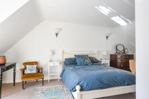 a bedroom with a bed and a desk and a chair at Stable Cottage in Bridport