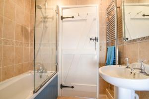 a bathroom with a shower and a sink and a tub at Stable Cottage in Bridport +31 photos