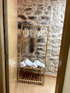 a room with a stone wall with a bunch of towels at Casa Rochiña in Pobra do Caramiñal
