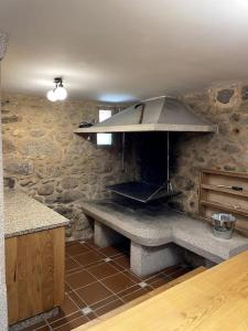 a kitchen with a stone wall with a stove at Casa Rochiña in Pobra do Caramiñal