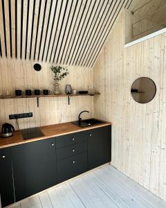 uma cozinha com um lavatório e um tecto de madeira em Sunset Village em Aglona