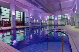 a large swimming pool in a large building at Village Hotel Swansea in Swansea