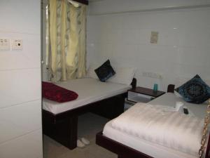 una piccola camera con due letti e una finestra di Relaince Inn a Hong Kong
