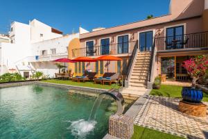 a house with a swimming pool with a fountain at Vila Origens Boutique Hotel Albufeira – Adults Only in Albufeira
