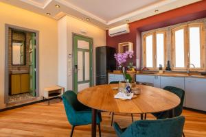 阿爾布費拉的住宿－Vila Origens Boutique Hotel Albufeira – Adults Only，厨房以及带木桌和椅子的用餐室。