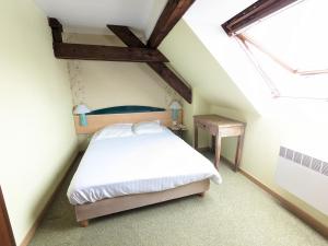 1 dormitorio con cama blanca y ventana en Hotel le Chasseur, en Illkirch-Graffenstaden