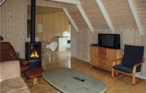 a living room with a table and a fireplace at Nice Home In Oksbl With 3 Bedrooms, Sauna And Wifi in Oksbøl