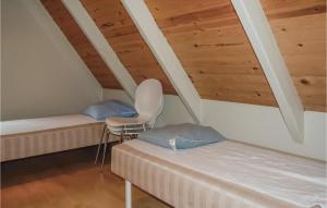 a room with two beds and a chair in a attic at Nice Home In Oksbl With 3 Bedrooms, Sauna And Wifi in Oksbøl