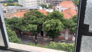 una ventana con vistas a los árboles y a un edificio en Aconchego do Lar Centro BH Apto 633 Rua da Bahia 187 en Belo Horizonte