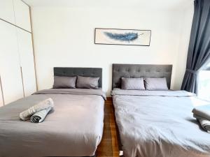 two beds sitting next to each other in a bedroom at Teega Suites #3101 Puteri Harbour Iskandar Puteri in Nusajaya