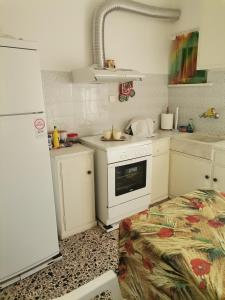 kuchnia z białymi szafkami i kuchenką w obiekcie Ορεινή φιλόξενη κατοικια 