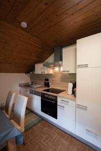 a kitchen with white appliances and a wooden ceiling at Ferienwohnung Zedlacher in Kartitsch