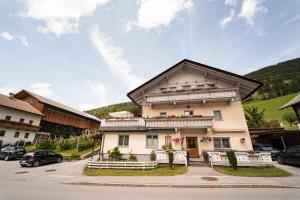 a building in the middle of a parking lot at Ferienwohnung Zedlacher in Kartitsch