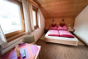 a small bedroom with a bed with red pillows at Ferienwohnung Zedlacher in Kartitsch