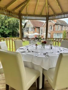 uma mesa branca com cadeiras e copos de vinho em Findon Manor Hotel em Worthing