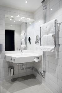 Baño blanco con lavabo y espejo en Vann Spa Hotell & Konferens, en Brastad