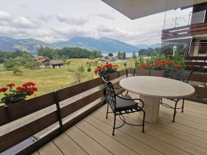 a table and chairs on a deck with a view at Alpine Stay Thun Gateway to Interlaken & Bernese Oberland in Einigen