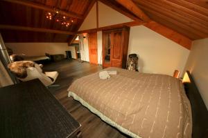 a bedroom with a bed in a room with wooden floors at Chalet les Blancs in Eygliers