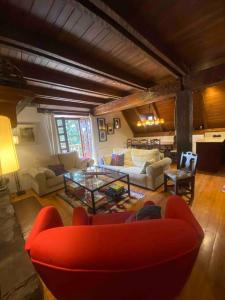 a living room with a red couch and a table at Casa TOP para 14 personas en Garós, Ideal esquí in Garós