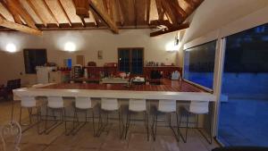 uma cozinha com um bar com bancos brancos em les bois de ravel chambres d'hôtes em Ravel