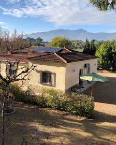 una pequeña casa con techo solar y sombrilla en Casa Rural Y Spa de Regina, 