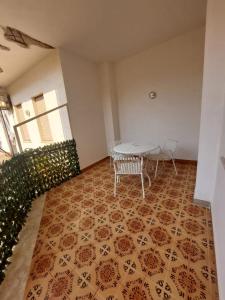 uma sala de jantar com uma mesa e cadeiras num piso de azulejo em Una Rosa Blu em Valderice