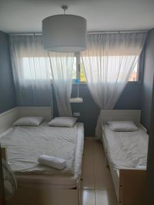 two beds in a room with two windows at Villa Costa Antigua A3 in Costa de Antigua