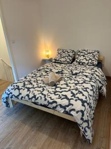 um quarto com uma cama com um edredão preto e branco em Maison de ville avec jardin em Valence