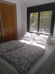 1 cama en un dormitorio con ventana grande en Casa Cas, en Jerez de la Frontera