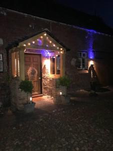 una casa con luces en la puerta por la noche en A luxury Boutique Barn set within 2 acre grounds 