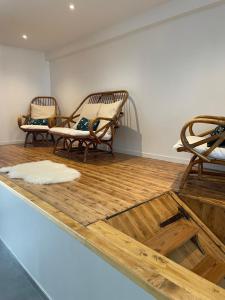 Zimmer mit 2 Stühlen und Holzboden in der Unterkunft La maison de Solange in Esquelbecq