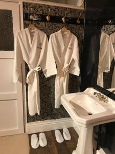 a bathroom with white robes and a sink at A luxury Boutique Barn set within 2 acre grounds 