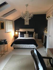 Un dormitorio con una cama grande y una lámpara de araña. en A luxury Boutique Barn set within 2 acre grounds 