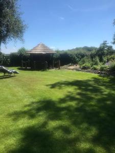 a large grass yard with a gazebo in the background at A luxury Boutique Barn set within 2 acre grounds 