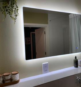 a mirror on a wall above a bathroom sink at Perfect Stay for Families & Business in CR2 - with FREE parking & 10mins from East Croydon in Purley